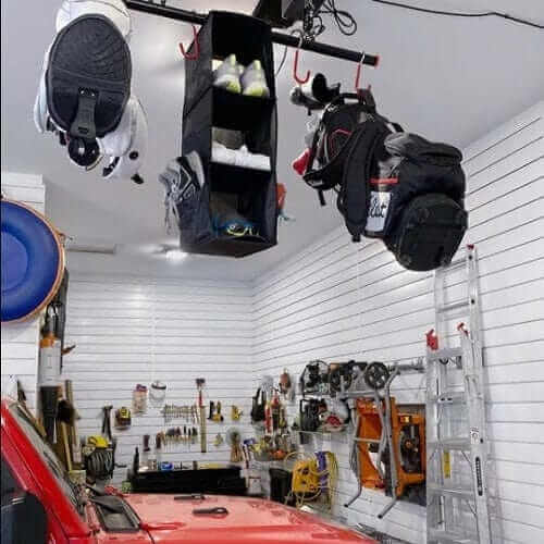 Garage Gator Golf Storage Lift - 220 lb 68223 - Raised with bags and shoes attached over workbench in garage